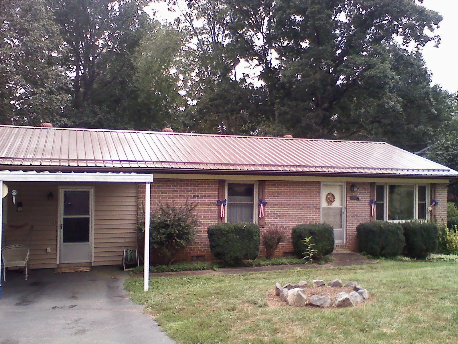 Bronze metal roof and carport on a brick ranch home — Roof Repair work by our crew in Paris